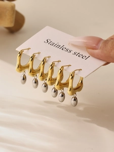 Close-up of two-tone stainless steel U-shaped stud earrings with gold and silver finish