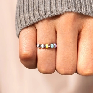 Close-up of s925 anxiety ring with colorful spinning beads worn on model hand
