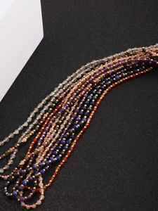 Macro shot of faceted natural stone beads with golden spacers on a textured surface