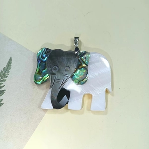 Macro detail of handmade elephant shell pendant with black pearl and abalone inlay