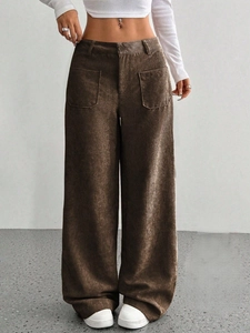 Dettaglio della trama di pantaloni larghi in velluto a coste marroni a vita alta