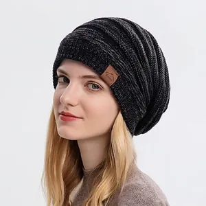 Unisex grey melange knit beanie hat with brown leather patch on white background