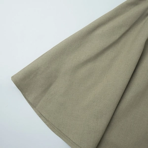 Detail of cotton linen fabric texture and stitching on pleated olive skirt hem