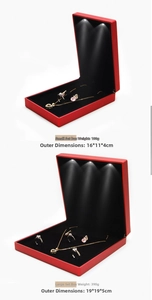 Detail of red jewelry boxes with integrated LED light highlighting necklaces and rings