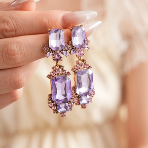 Detail view of vintage geometric square earrings with purple crystals on a female model