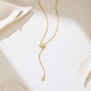 Macro detail of gold S925 sterling silver Y-shaped necklace with zircon star pendants