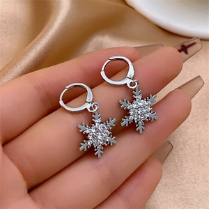 Macro shot of silver snowflake earrings with sparkling rhinestones and elegant tassels