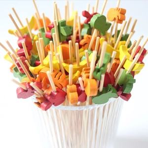 Colorful bamboo skewers with animal-shaped wooden toppers for cocktails and fruit appetizers