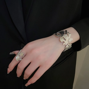 Vista dettagliata del bracciale rigido argento a foglia traforata con anello