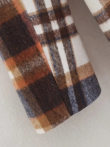 Detailed close-up showing the wool-like texture and brown plaid pattern of the blazer jacket