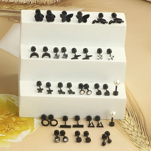 Macro detail of black stud earring set featuring heart, star, and moon shapes on stand