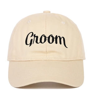 Close-up of Groom black embroidery on beige cotton baseball cap with classic curved brim