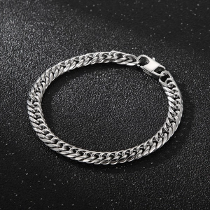 Macro view of silver stainless steel Cuban link bracelet with a secure lobster clasp