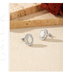 Detail shot of S925 silver oval opal earrings with halo cubic zirconia in warm lighting