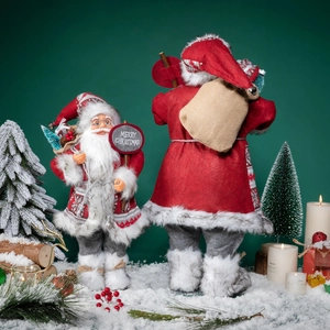 Classic Santa Claus figures with Merry Christmas sign on artificial snow background