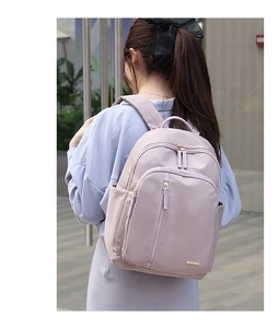 Mochila de tela Oxford color púrpura claro para mujer mostrada por una modelo en la ciudad