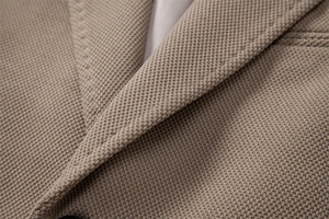 Gros plan du col de blazer kaki en tissu gaufré avec détails de coutures précis