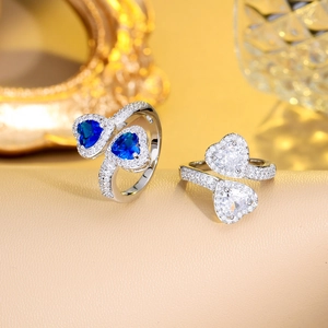 Close-up of double heart rings featuring deep blue and clear sapphire zircon stones