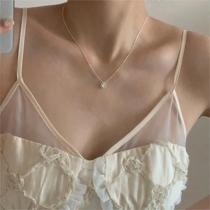 Close-up of a 925 sterling silver flower pendant necklace on a model's neck