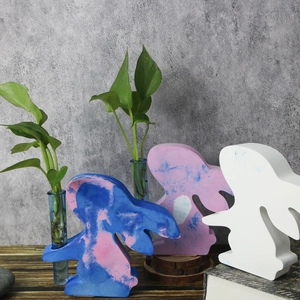 Detailed close-up of rabbit-shaped vases for hydroponics in blue, pink and white finishes