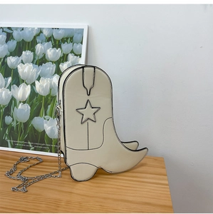 Detail of boot-shaped crossbody bag in cream white with black stitching and star pattern