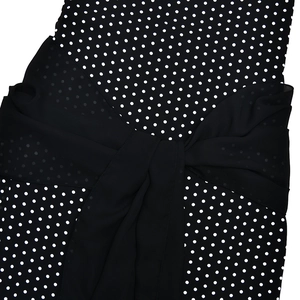 Detail view of the black polka dot dress featuring a large chiffon bow on the back