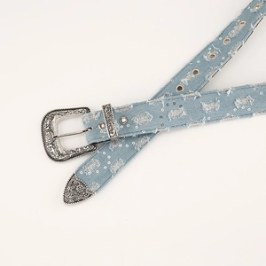 Detail of light blue denim belt with silver sequins and vintage engraved metal buckle