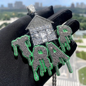 Macro shot of silver hip hop pendant with cubic zirconia and green glow letters