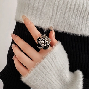 Detail of vintage flower ring with black petals, sparkling rhinestones and center pearl