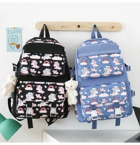 Detail view of nylon unicorn school bags in black and blue with bear plush pendant