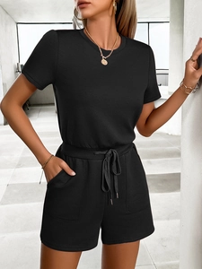 Detailed view of women's black short sleeve romper with drawstring waist and front pockets