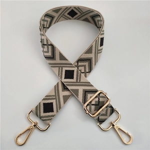 Detail of adjustable geometric jacquard canvas strap with premium gold metal hooks