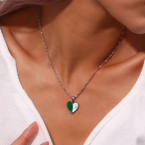 Detailed view of women's heart pendant necklace with green and white shell inlay
