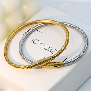 Minimalist 18k gold and silver snake chain bracelets on a white jewelry gift box