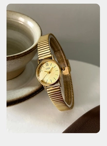 Detail of GEDI women's gold watch with flexible metal stretch band and Roman numeral dial