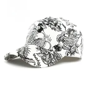 Dettaglio del cappello bianco con stampa floreale nera e struttura a corona rigida