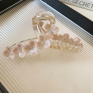 Vue détaillée de la pince à cheveux en résine avec fleurs élégantes et strass brillants