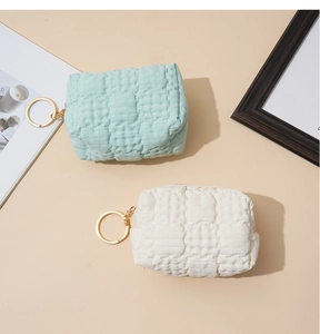 Close-up of mint green and cream waffle textured mini coin purses with golden ring keychains