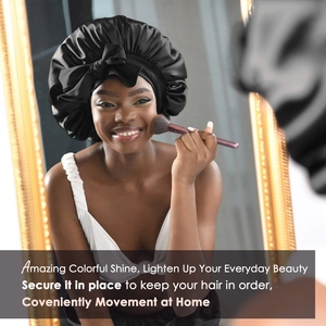 Detail view of a black satin hair bonnet with a bow on a model applying makeup