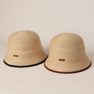 Dettaglio del cappello a secchiello in rafia fatto a mano con bordo a contrasto