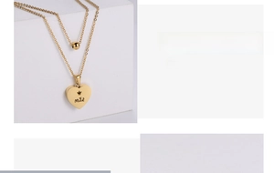 Detail of gold double-layer necklace with heart pendant and crown engraving for Mother's Day