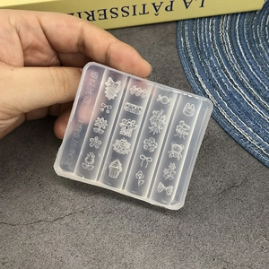 Macro view of clear silicone nail art mold featuring bear, flower, and bow designs