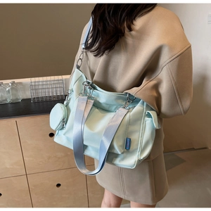 Detail of light blue nylon tote bag with wide strap and matching round coin purse detail