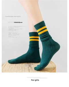 Detailed texture of dark green ribbed knit socks featuring yellow sporty stripes