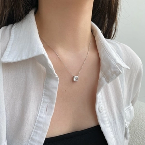 Gros plan du collier en argent S925 avec pendentif en zircon carré porté par un mannequin