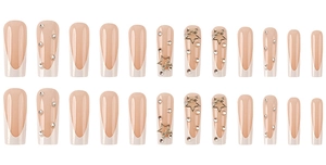 Detail of 24pcs long French press-on nails with white tips, rhinestones, and gold stars
