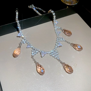 Macro detail of champagne pear-cut crystals and pavé zircon fringe on a vintage necklace
