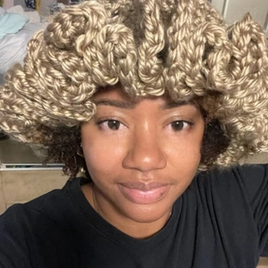 Detailed close-up of light brown chunky knit hat featuring unique wavy ruffled brim design