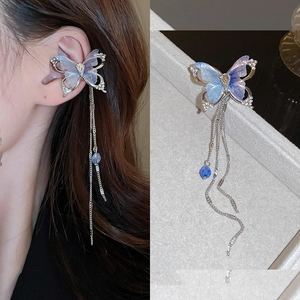 Detail of blue gradient butterfly ear cuff with long metallic tassels and rhinestones