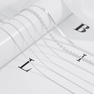 Close-up of various S925 silver necklace chains including snake and box link styles